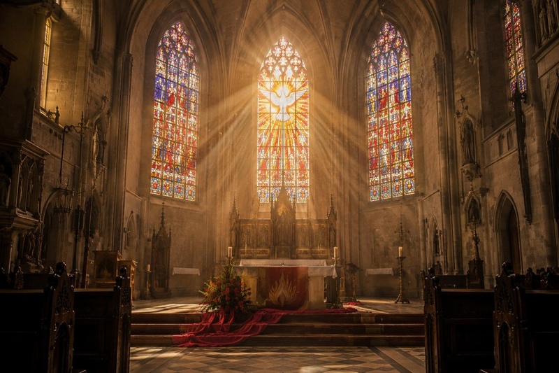 Kirchenfenster mit farbigen Lichtstrahlen als realistisches Pfingsten Bild